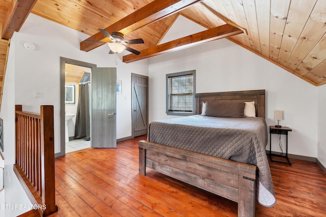 bedroom with hardwood / wood-style floors, vaulted ceiling with beams, ensuite bath, and wood ceiling