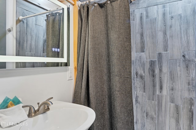 bathroom with curtained shower and sink