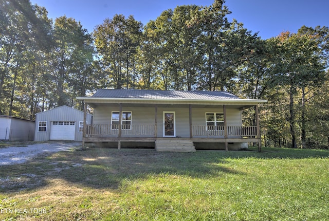 view of front facade featuring a front lawn, a porch, an outbuilding, and a garage