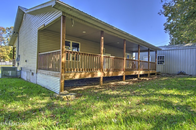 back of house with a shed, a lawn, and central AC unit