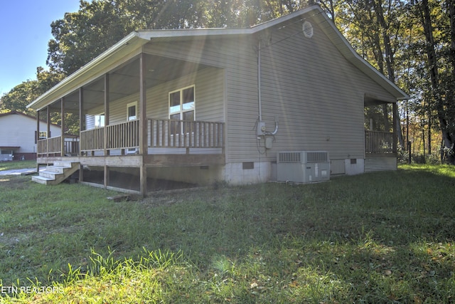 view of home's exterior with a yard and central AC