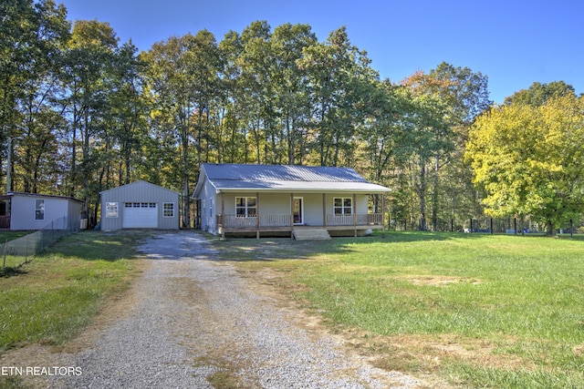 view of front of property with covered porch, a front yard, a garage, and an outdoor structure