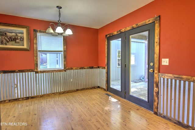 spare room featuring light hardwood / wood-style flooring and a notable chandelier