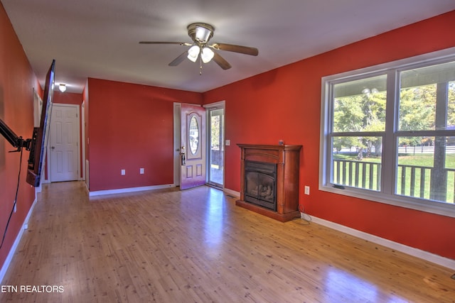 unfurnished living room with light hardwood / wood-style floors, ceiling fan, and a wealth of natural light