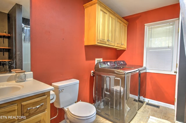 bathroom with walk in shower, toilet, washing machine and dryer, vanity, and tile patterned floors