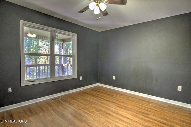 empty room with ceiling fan and hardwood / wood-style flooring