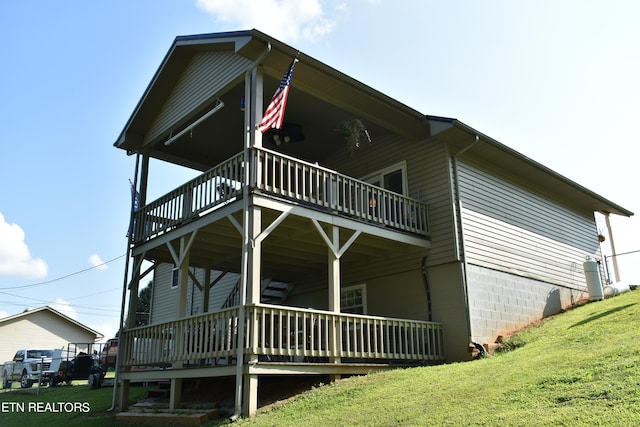 view of side of home featuring a deck and a lawn