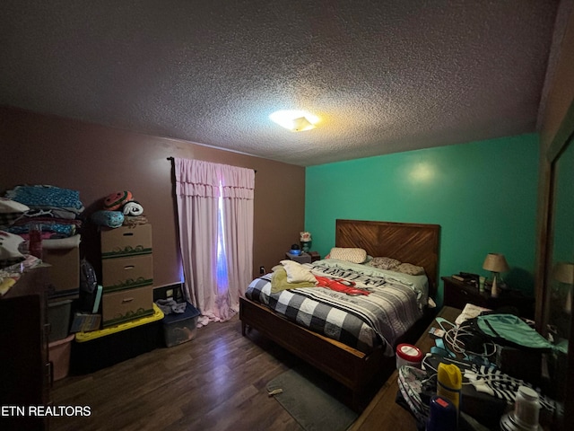 bedroom with a textured ceiling and dark wood-type flooring