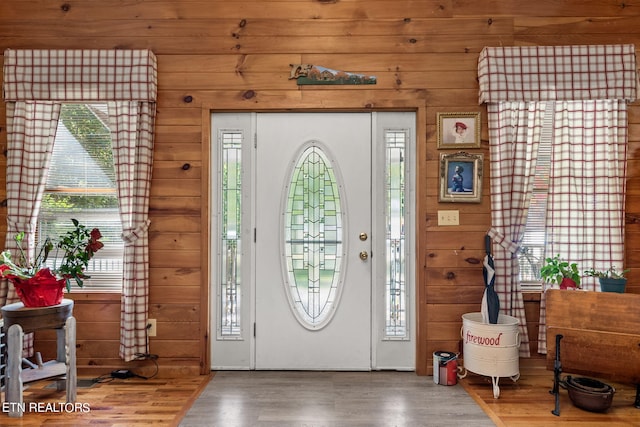 entrance foyer featuring hardwood / wood-style floors and wooden walls