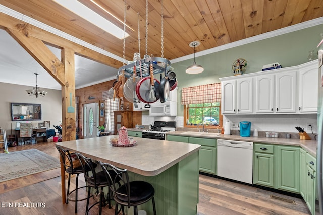 kitchen with white cabinetry, wood-type flooring, pendant lighting, sink, and white appliances