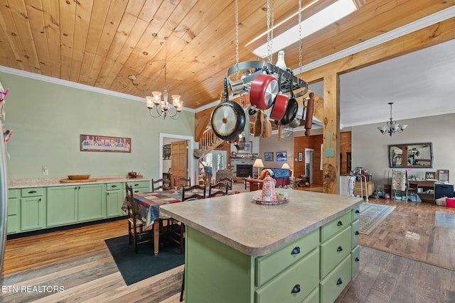 kitchen featuring a kitchen island, decorative light fixtures, green cabinets, and wood-type flooring