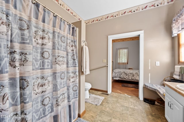 bathroom featuring a wealth of natural light, vanity, and toilet