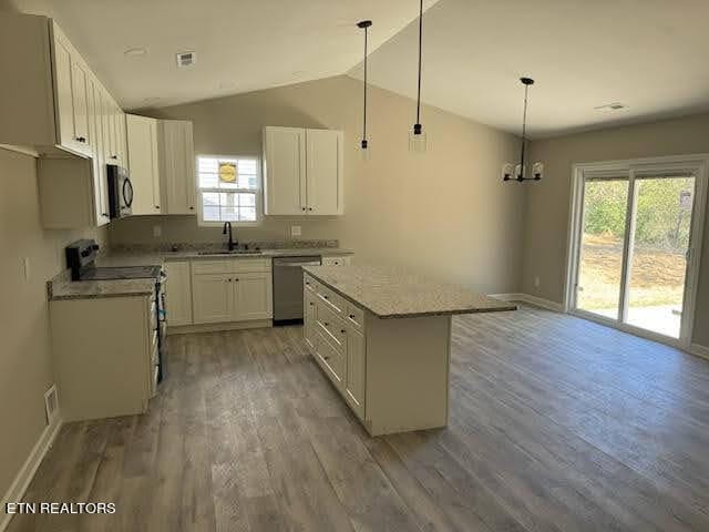 kitchen with white cabinetry, stainless steel appliances, decorative light fixtures, and a wealth of natural light