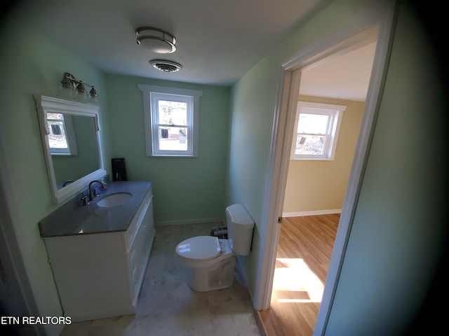 bathroom with visible vents, toilet, a healthy amount of sunlight, and vanity