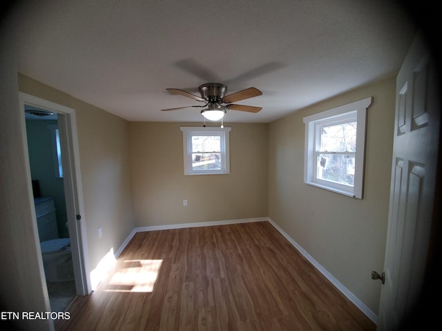 unfurnished bedroom featuring wood finished floors, baseboards, and ceiling fan