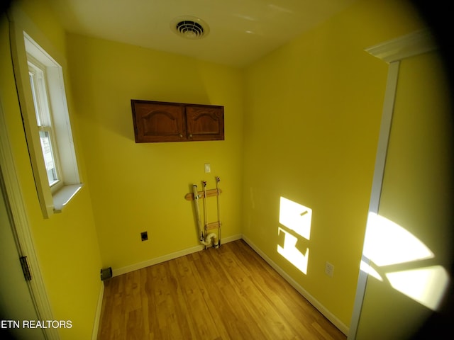 clothes washing area with wood finished floors, visible vents, baseboards, laundry area, and washer hookup