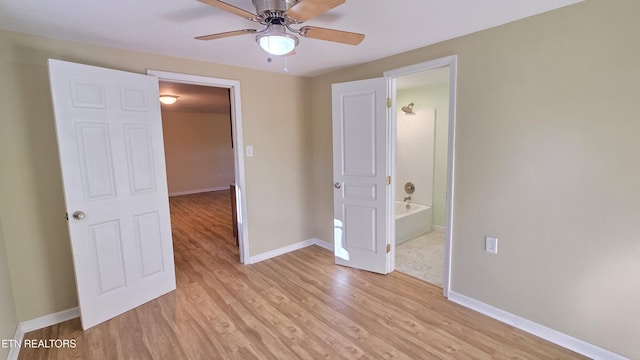 unfurnished bedroom featuring light wood-type flooring, baseboards, and connected bathroom