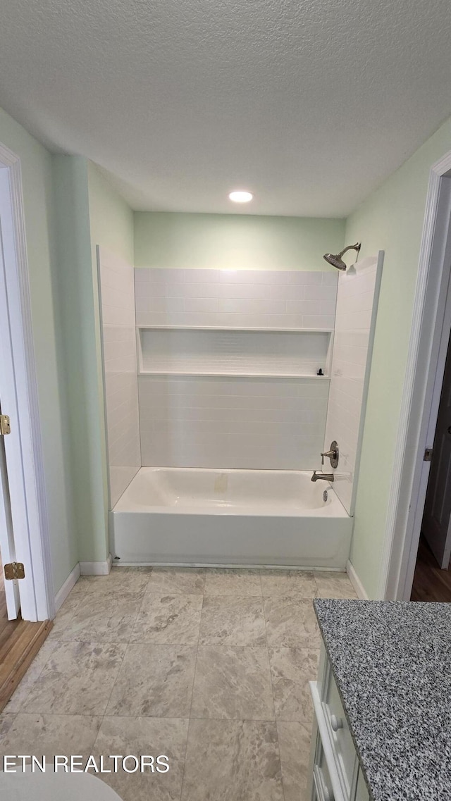 full bath featuring shower / bath combination, baseboards, and a textured ceiling