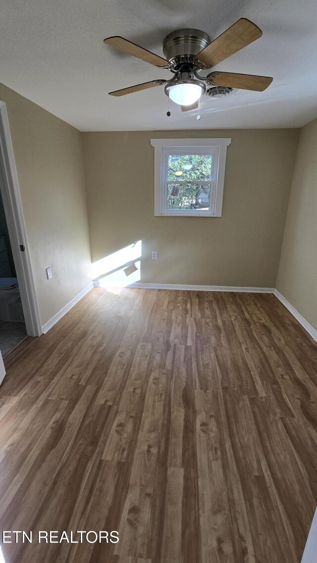 unfurnished bedroom with dark wood-style floors, ceiling fan, and baseboards