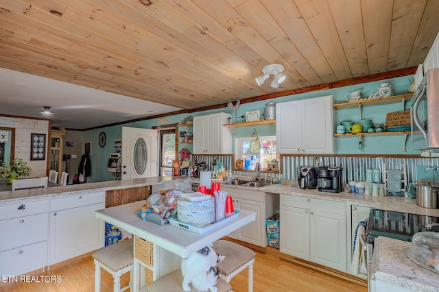 kitchen featuring white cabinets, sink, and light wood-type flooring