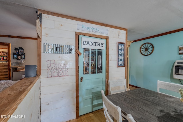 dining area with crown molding, light hardwood / wood-style flooring, and heating unit