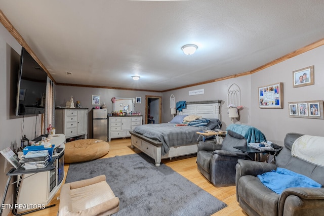 bedroom featuring stainless steel fridge, crown molding, and light hardwood / wood-style floors