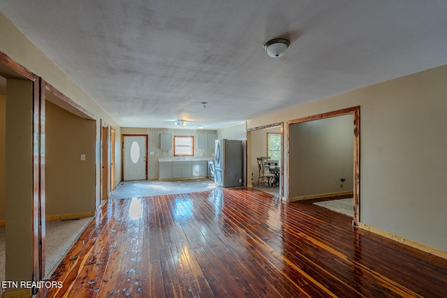 unfurnished living room featuring a textured ceiling and hardwood / wood-style floors