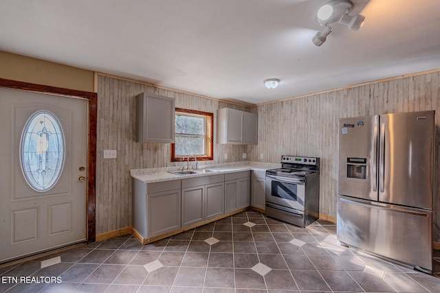 kitchen with appliances with stainless steel finishes, sink, gray cabinets, and tile patterned flooring