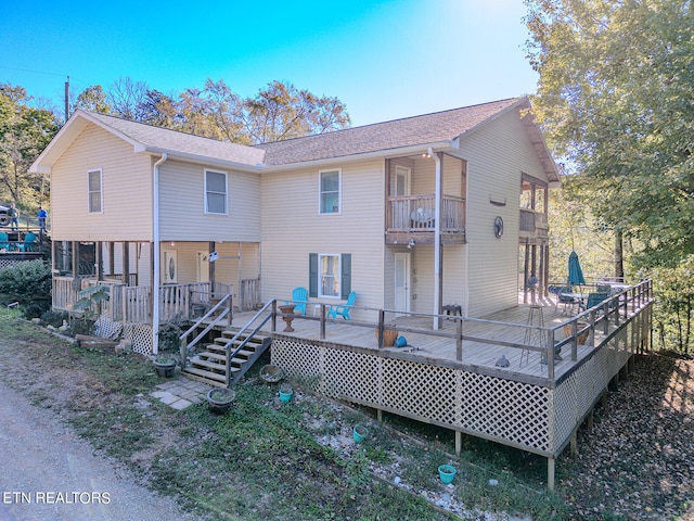 rear view of house featuring a wooden deck