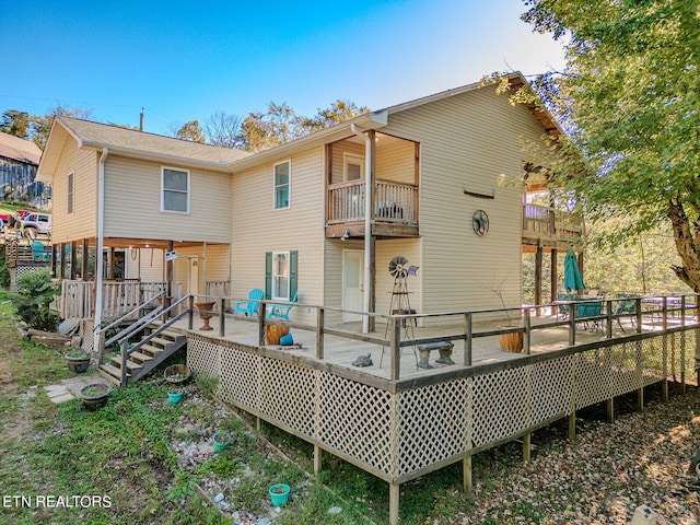 rear view of property featuring a deck and a balcony