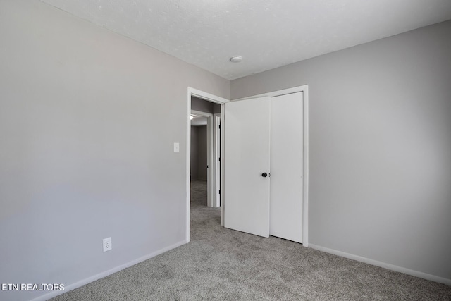 unfurnished bedroom featuring a closet and light colored carpet