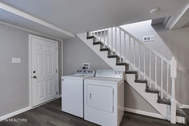 clothes washing area with separate washer and dryer and dark hardwood / wood-style flooring