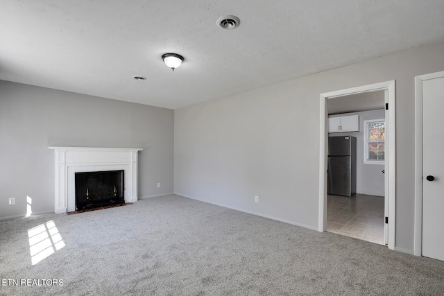 unfurnished living room with a brick fireplace and light colored carpet