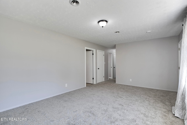 carpeted empty room with a textured ceiling