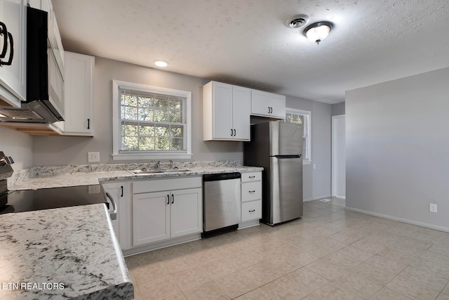 kitchen featuring light stone countertops, sink, white cabinets, and stainless steel appliances