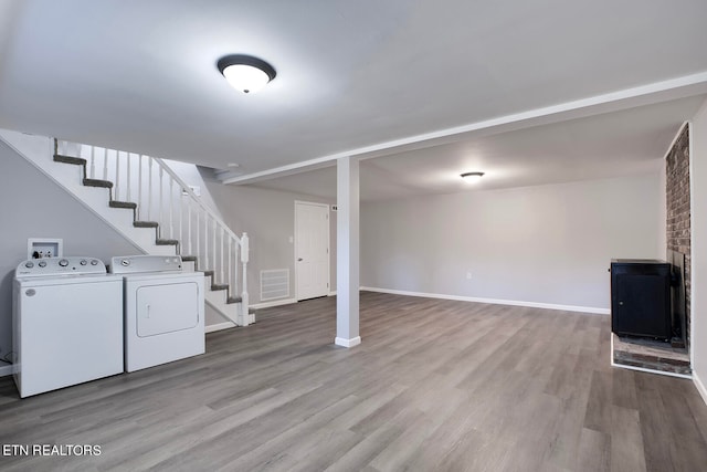 basement featuring light hardwood / wood-style floors and washing machine and dryer