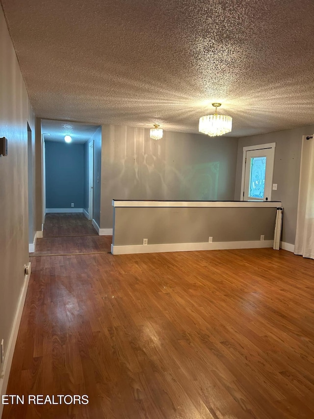 unfurnished room featuring hardwood / wood-style floors and a textured ceiling