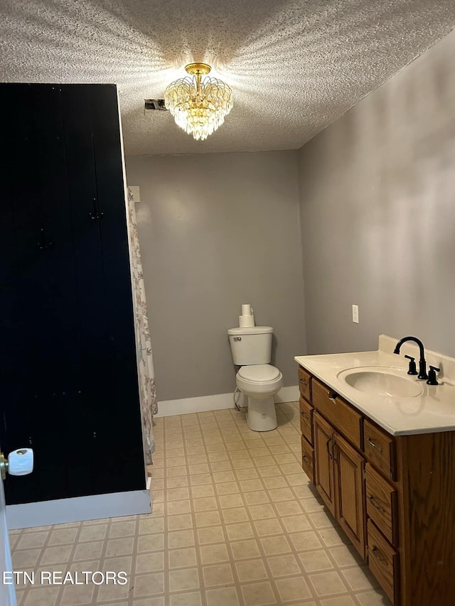 bathroom featuring vanity, a notable chandelier, a textured ceiling, and toilet