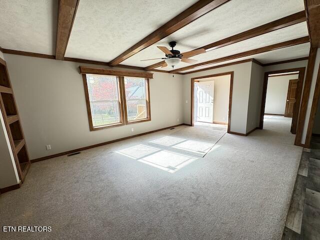 carpeted spare room with a textured ceiling, beam ceiling, and ceiling fan