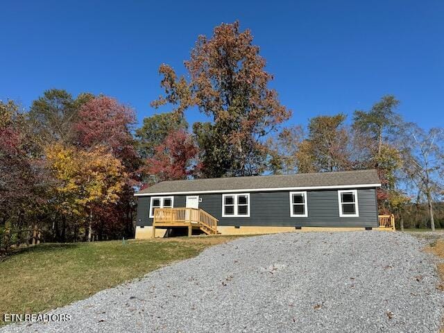 view of front facade with a front lawn and a wooden deck