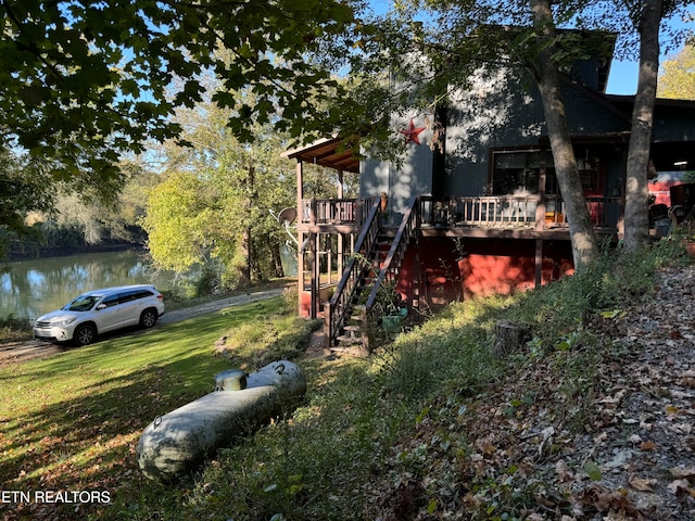 view of yard with a deck with water view