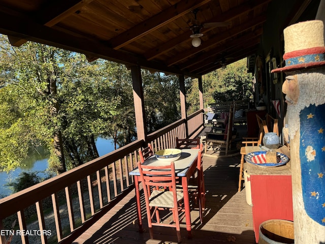 wooden deck featuring a water view and ceiling fan