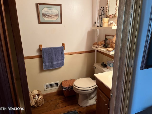 bathroom featuring vanity, wood-type flooring, and toilet