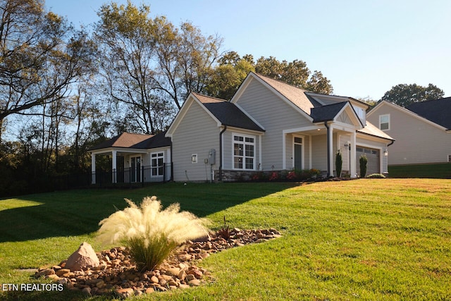 view of front of home featuring a garage, stone siding, and a front yard