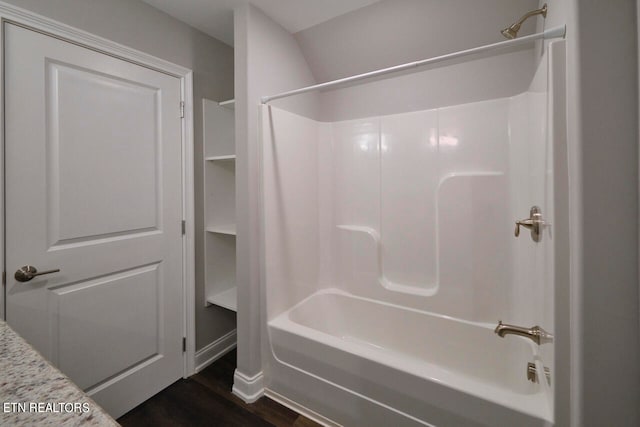 bathroom with hardwood / wood-style floors and shower / bathtub combination