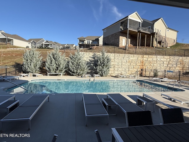 pool featuring stairway, fence, and a patio