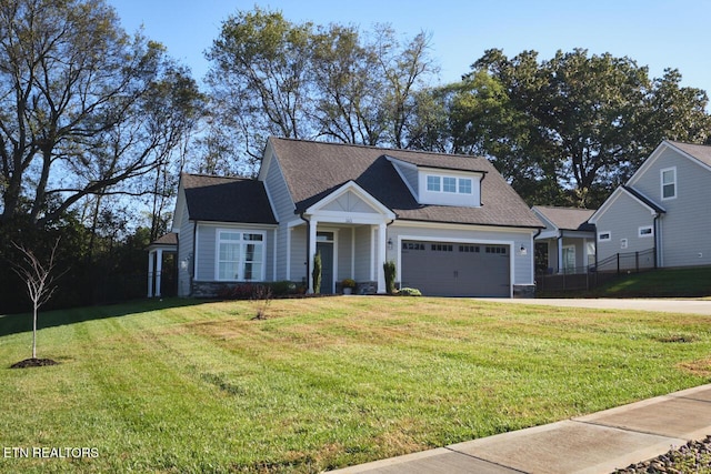 view of front of house featuring an attached garage, driveway, and a front lawn