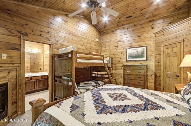bedroom with wood walls, wooden ceiling, and ensuite bath