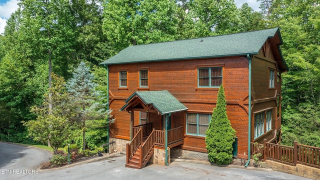 rustic home featuring a shingled roof