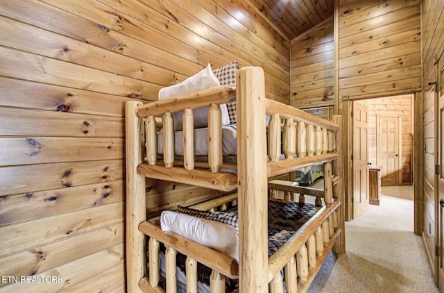 bedroom featuring wooden walls, wood ceiling, carpet floors, and lofted ceiling